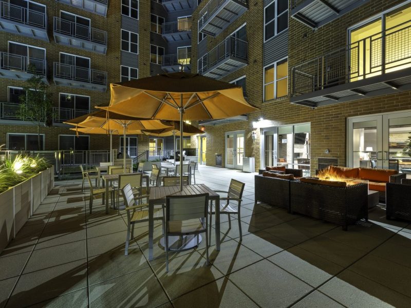 This image shows an expansive view of the Premium Community Amenities, specifically the outdoor fire pit and community patio or balcony that was perfect for outdoor fun with family and friends.
