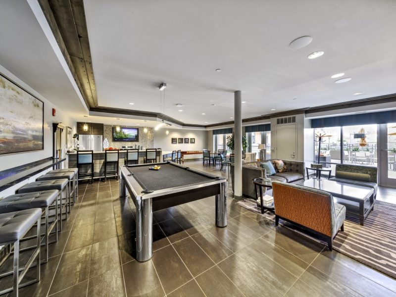 This image shows the social lounge with kitchen, billiard area, and seating.